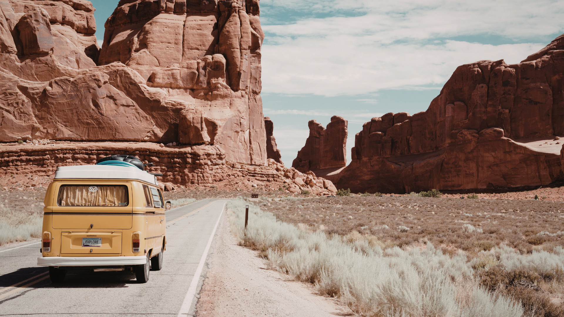 Van aménagé progressant sur une route au cœur d’un canyon